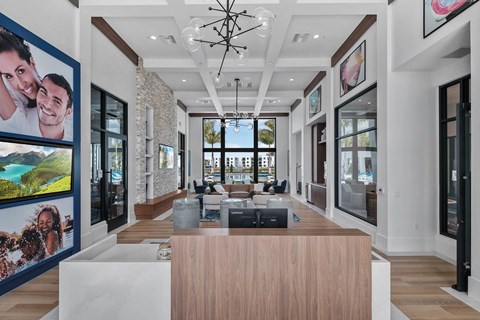 the living room has large windows and a large table and chairs at Altis Blue Lake, Lake Worth, 33467
